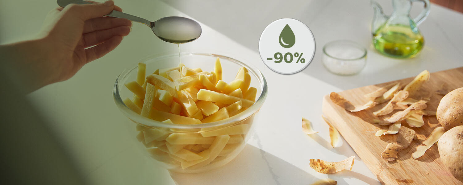 Na obrazie widoczna jest miska z pokrojonymi ziemniakami, nad którą trzymana jest łyżka. Obok znajduje się deska z obierkami ziemniaków, a na obrazie widnieje symbol kropli z napisem \'-90%\'.