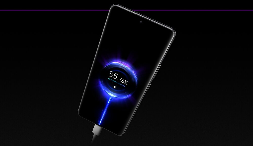 Smartfon z wyświetlaczem pokazującym stan naładowania baterii na poziomie 85,36%. Urządzenie jest podłączone do ładowarki, a wokół wskaźnika naładowania widoczny jest efekt świetlny.