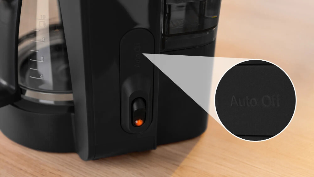 Czarny ekspres do kawy z widocznym szklanym dzbankiem z miarką. Na obudowie znajduje się przycisk z napisem \'Auto Off\'.