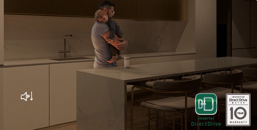 W kuchni przy blacie stoi osoba trzymająca dziecko. Na dole widoczne są dwa loga: \'Inverter DirectDrive\' i \'Inverter Direct Drive Motor 10 Year Warranty\'.