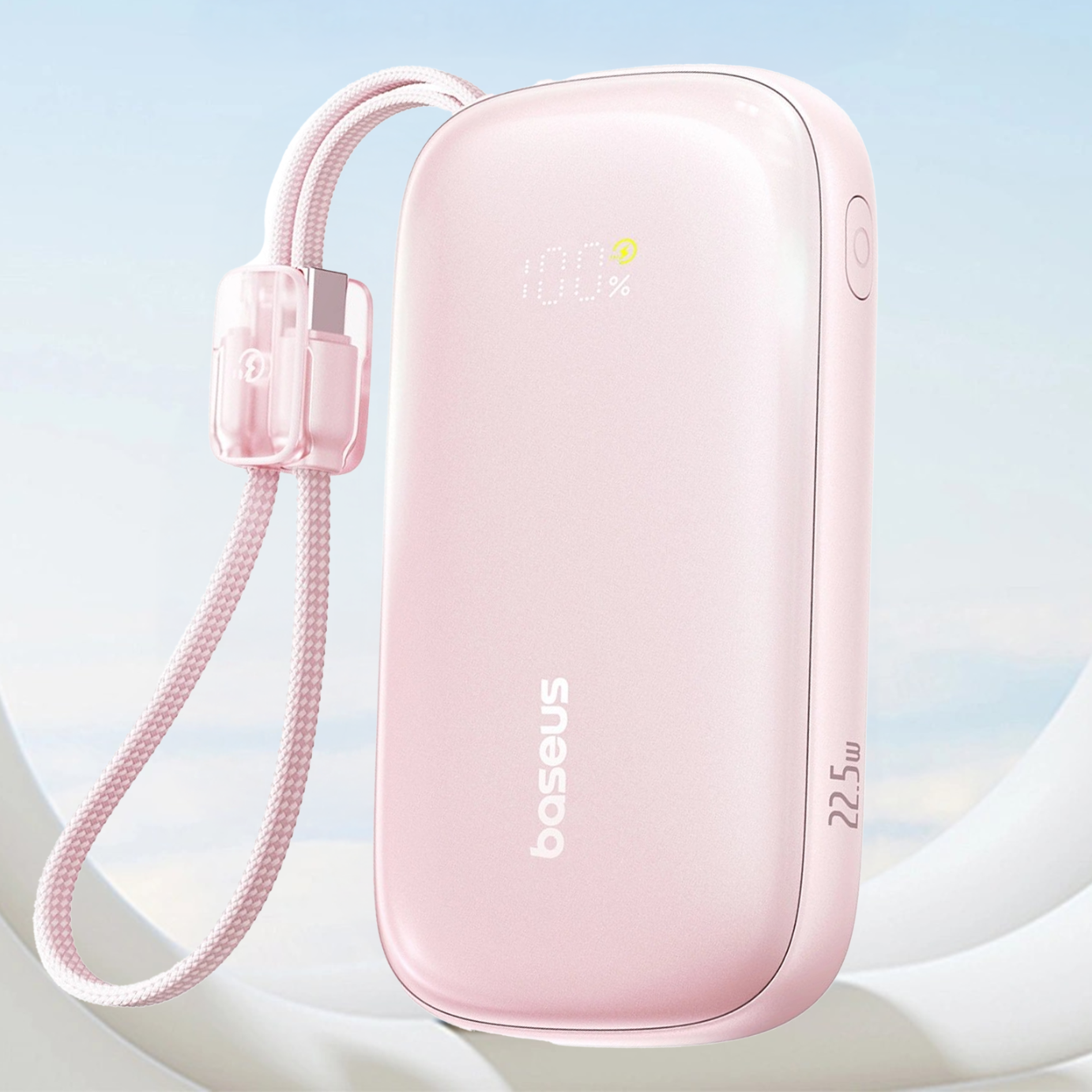 Różowy power bank z logo \'baseus\' i oznaczeniem \'22.5W\', z wyświetlaczem pokazującym \'100%\'. Do urządzenia przymocowany jest pleciony kabel z przezroczystą osłoną.