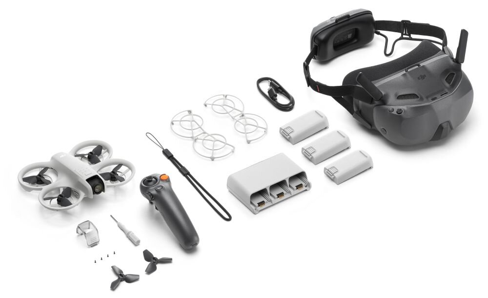 Na obrazie znajduje się zestaw drona z akcesoriami, w tym dron, kontroler, trzy baterie, ładowarka, gogle VR, śmigła i kable. Widoczne jest logo DJI na goglach.