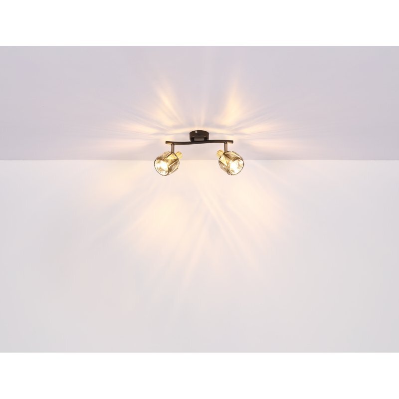 Na obrazie widoczna jest lampa sufitowa z dwoma źródłami światła, emitująca ciepłe światło na biały sufit. Klosze lampy mają złoty odcień i są wykonane z przydymionego szkła.