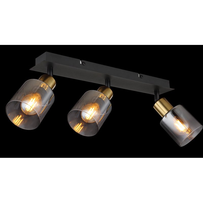 Lampa sufitowa z trzema reflektorami, każdy z przydymionym szklanym kloszem i złotymi elementami, zamontowana na czarnej matowej listwie. Żarówki emitują ciepłe światło.