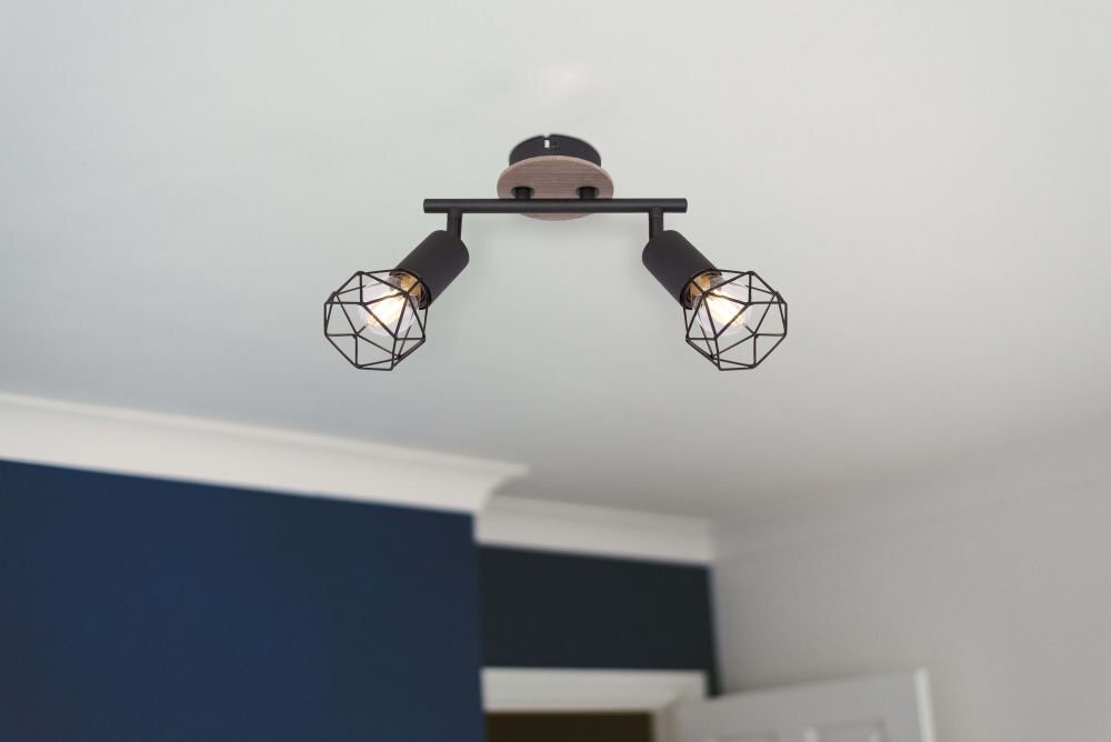 Na suficie zamontowana jest lampa sufitowa z dwoma źródłami światła w czarnych metalowych oprawach z geometrycznymi kloszami. W tle widoczna jest część pomieszczenia z białym sufitem i granatową ścianą.