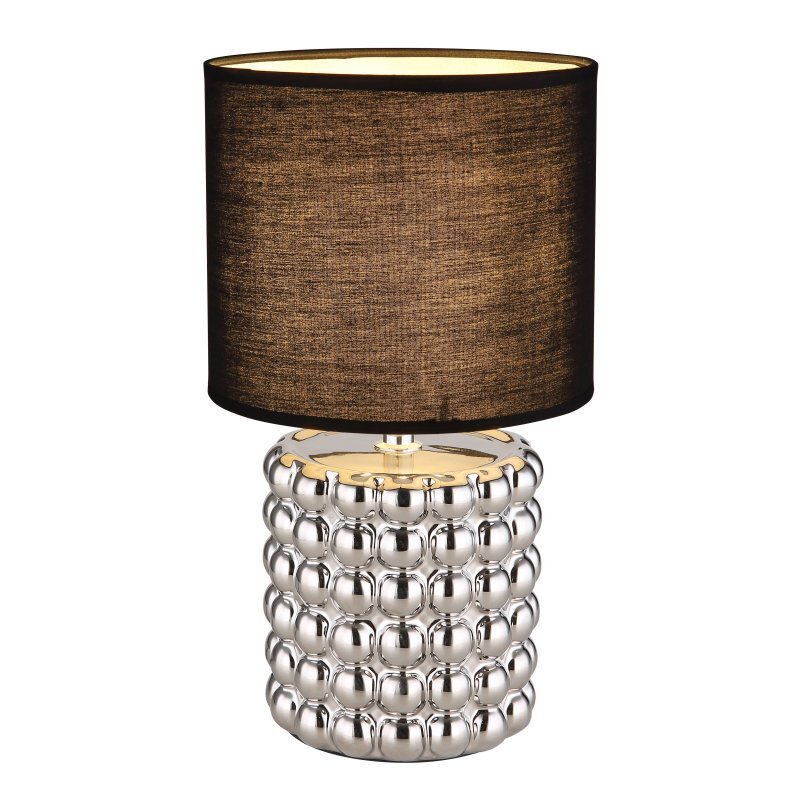 Lampa stołowa z czarnym abażurem i srebrną, ceramiczną podstawą o wypukłej strukturze. Abażur ma cylindryczny kształt, a podstawa jest ozdobiona kulistymi wypustkami.