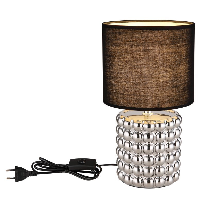 Lampa stołowa z czarnym abażurem i srebrną, ceramiczną podstawą o fakturze kul. Do lampy dołączony jest czarny kabel z wtyczką i przełącznikiem.