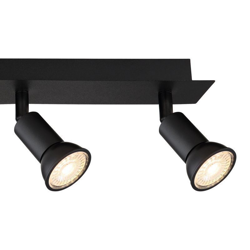 Czarna matowa lampa sufitowa z dwoma reflektorami zamontowanymi na prostokątnej podstawie. Reflektory są skierowane w dół i emitują ciepłe światło.