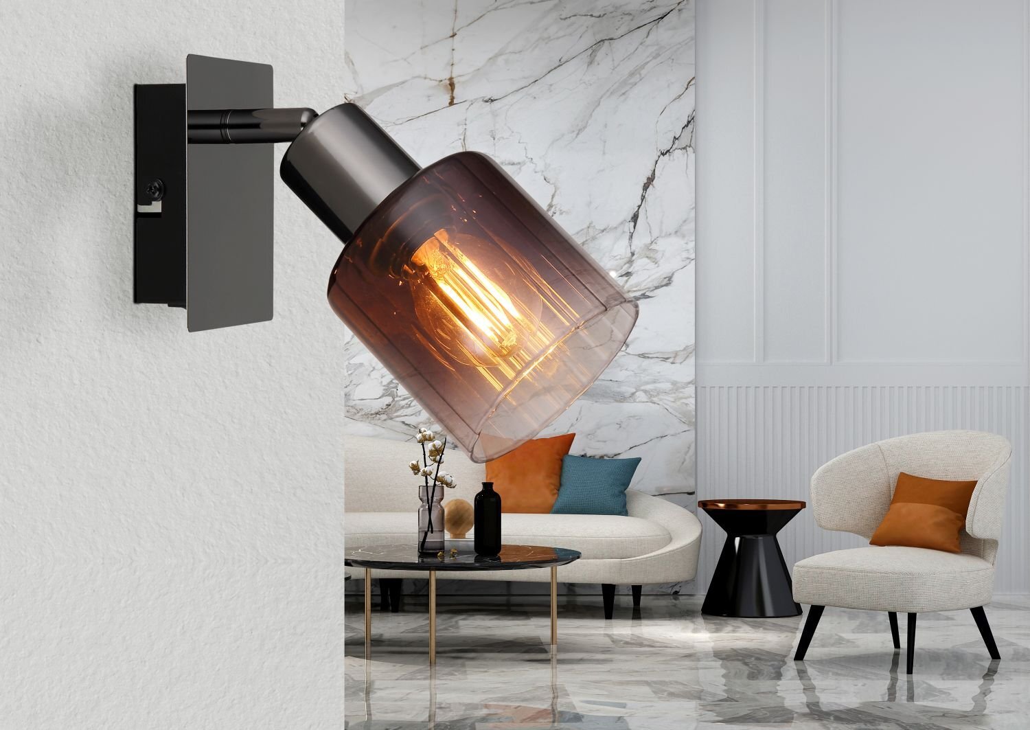 Na obrazie widoczna jest nowoczesna lampa sufitowa z przezroczystym kloszem, przez który widać żarówkę. W tle znajduje się elegancko urządzony salon z marmurową ścianą, sofą i fotelami.