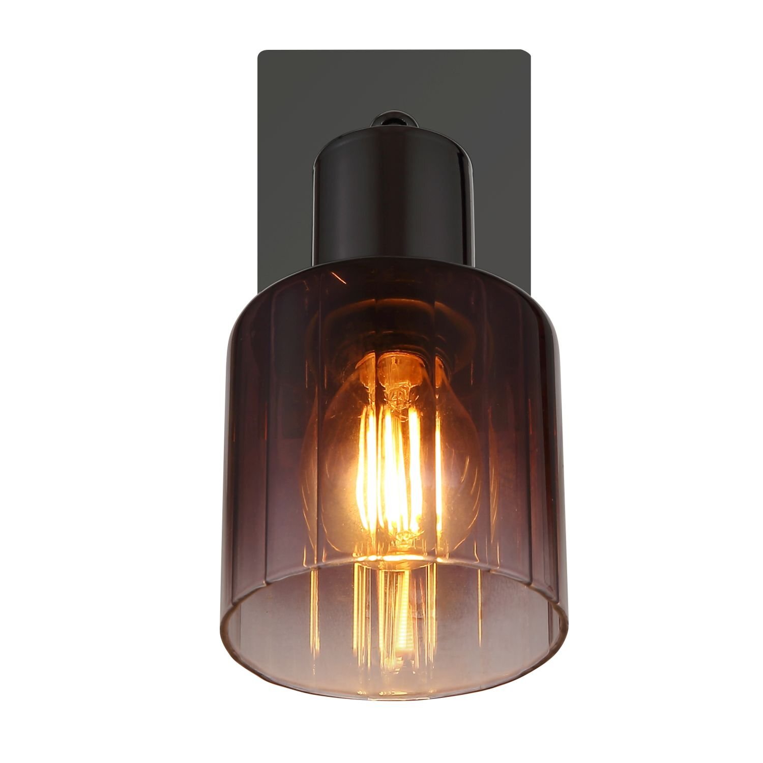 Lampa sufitowa z przezroczystym, przyciemnianym kloszem, przez który widać żarówkę emitującą ciepłe światło. Klosz zamocowany jest na prostokątnej, ciemnej podstawie.