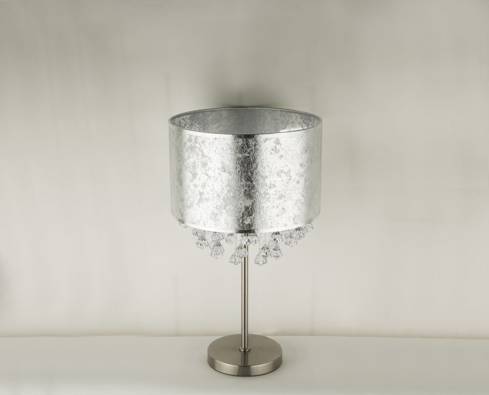 Lampa stołowa z satynowym, srebrnym abażurem tekstylnym i akrylowymi kryształkami. Posiada metalową podstawę i prosty, elegancki design.