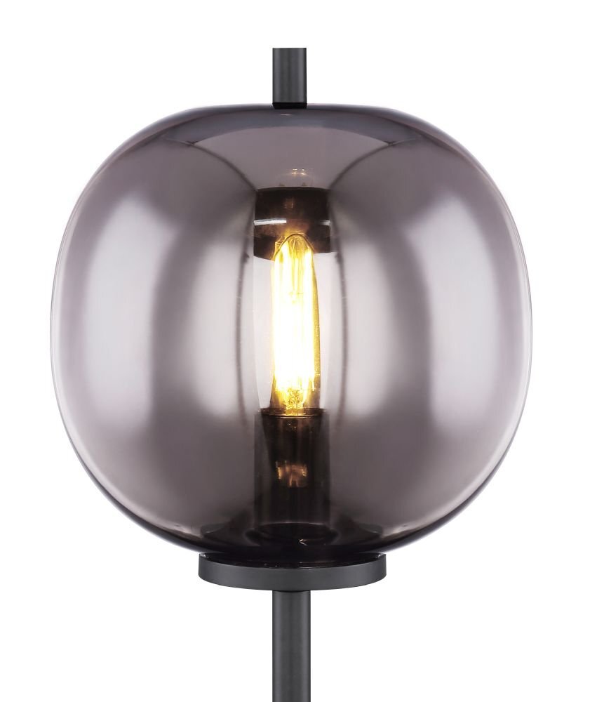 Lampa stołowa z czarną metalową podstawą i szklanym kloszem w kolorze grafitowym, wewnątrz widoczna żarówka emitująca ciepłe światło.
