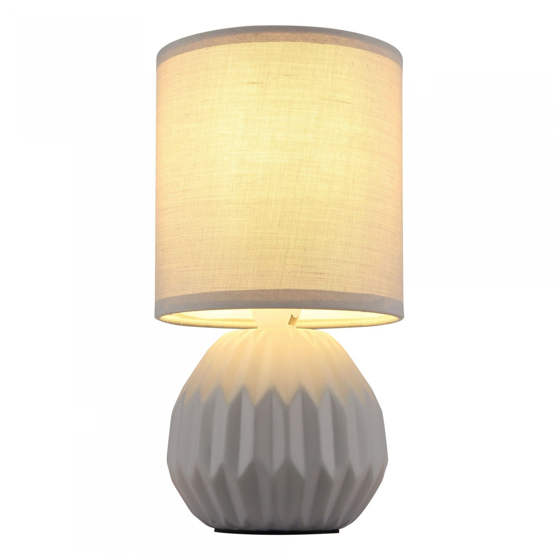 Lampa stołowa z cylindrycznym, jasnym abażurem i dekoracyjną, żłobioną podstawą w kolorze białym.
