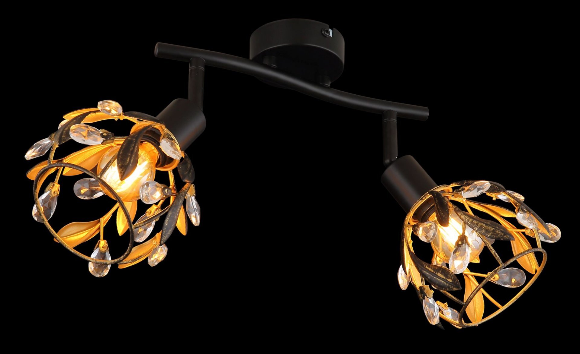 Lampa reflektorowa z dwoma źródłami światła, ozdobiona metalowymi liśćmi i przezroczystymi kryształkami, zamontowana na czarnym uchwycie sufitowym. Światło emituje ciepły, żółty blask.