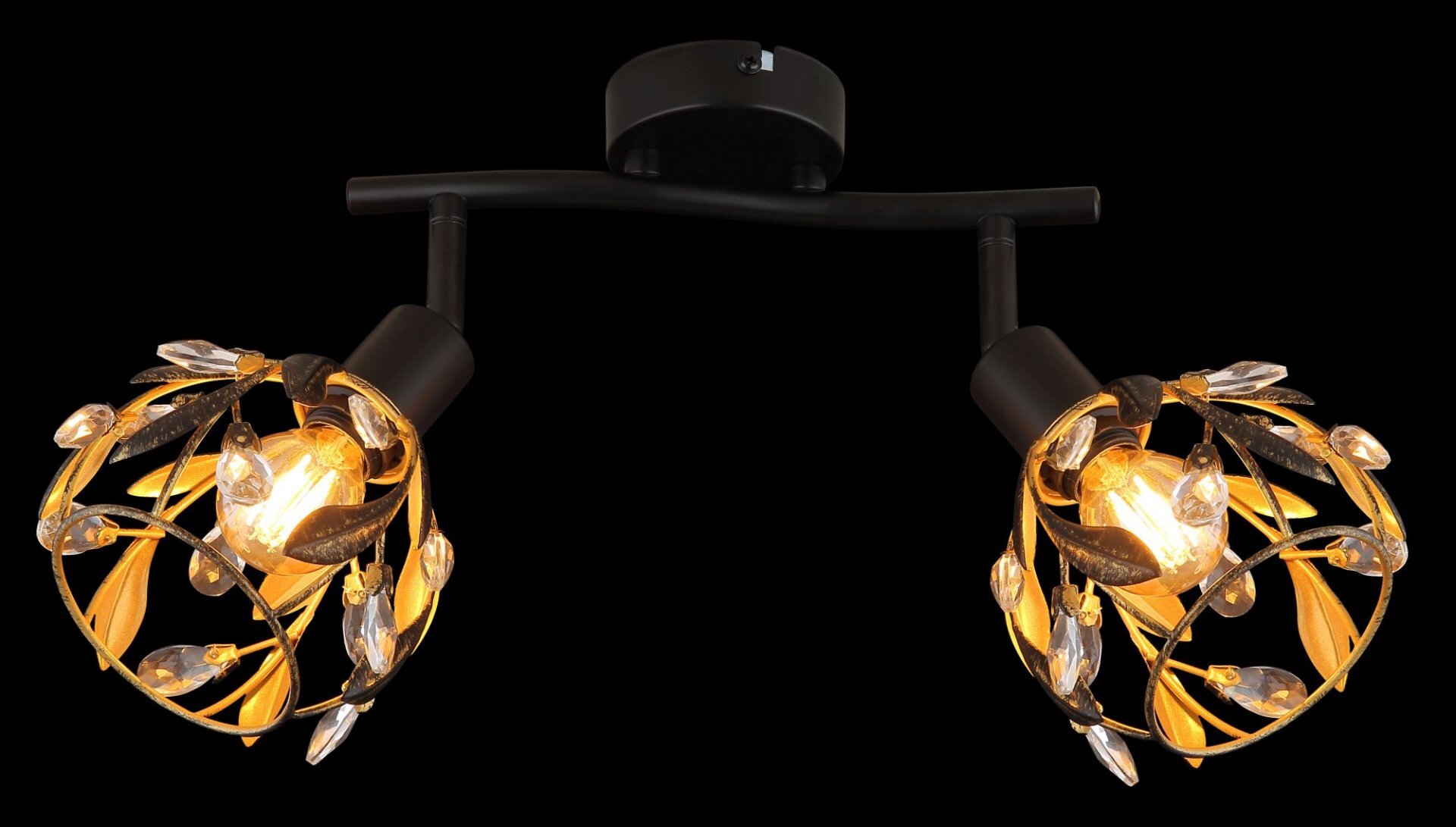 Lampa reflektorowa z dwoma źródłami światła, ozdobiona metalowymi liśćmi i przezroczystymi kryształkami, zamontowana na czarnym uchwycie sufitowym. Światło emituje ciepły, żółty blask.