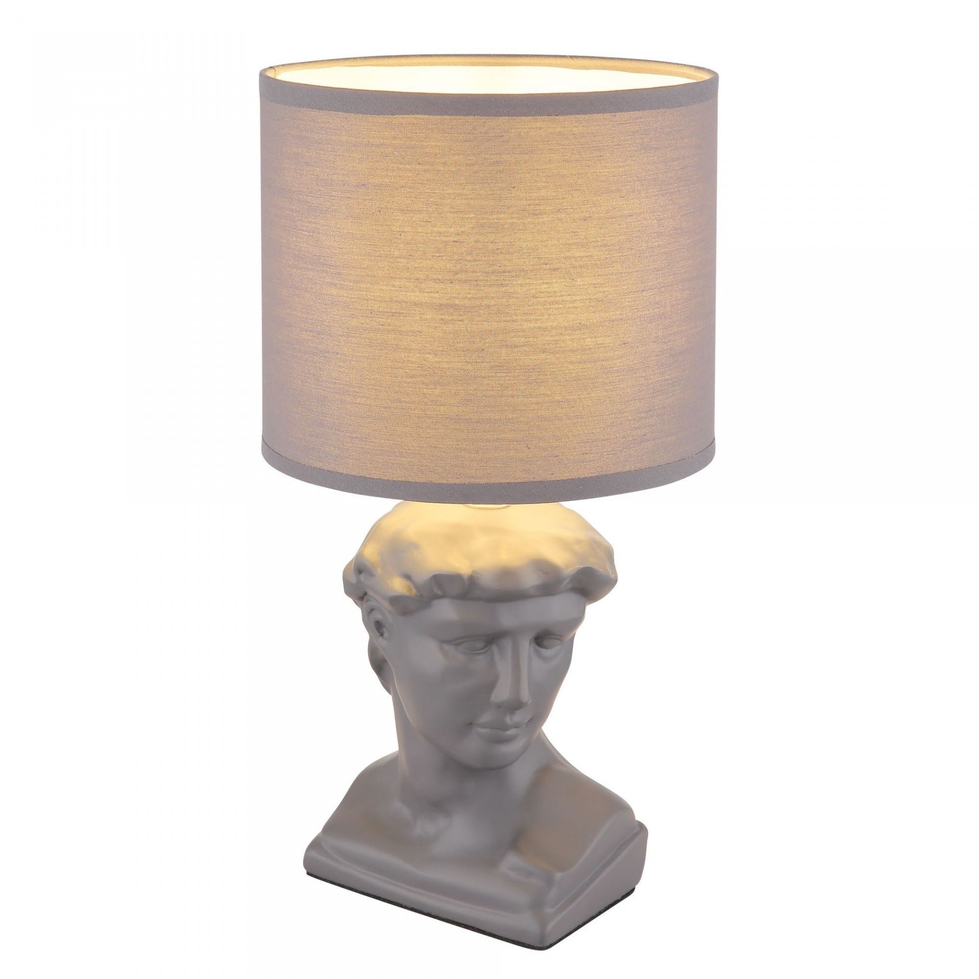 Lampa stołowa z abażurem w kształcie walca, osadzona na podstawie przypominającej popiersie klasycznej rzeźby. Abażur ma jasny kolor, a podstawa jest w odcieniu szarości.