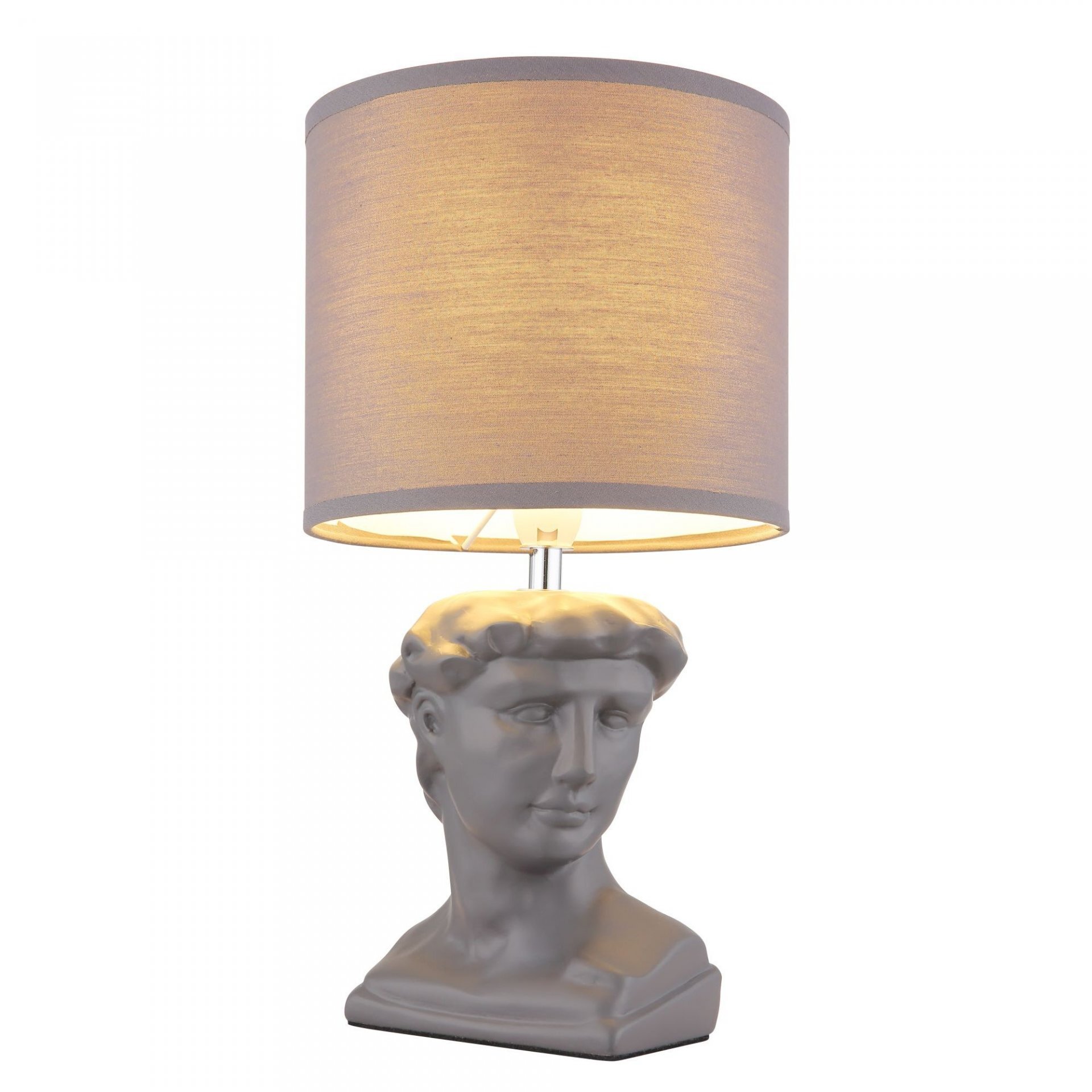 Lampa stołowa z abażurem w kształcie walca, osadzona na podstawie przypominającej popiersie klasycznej rzeźby. Abażur ma jasny, beżowy kolor, a podstawa jest szara.