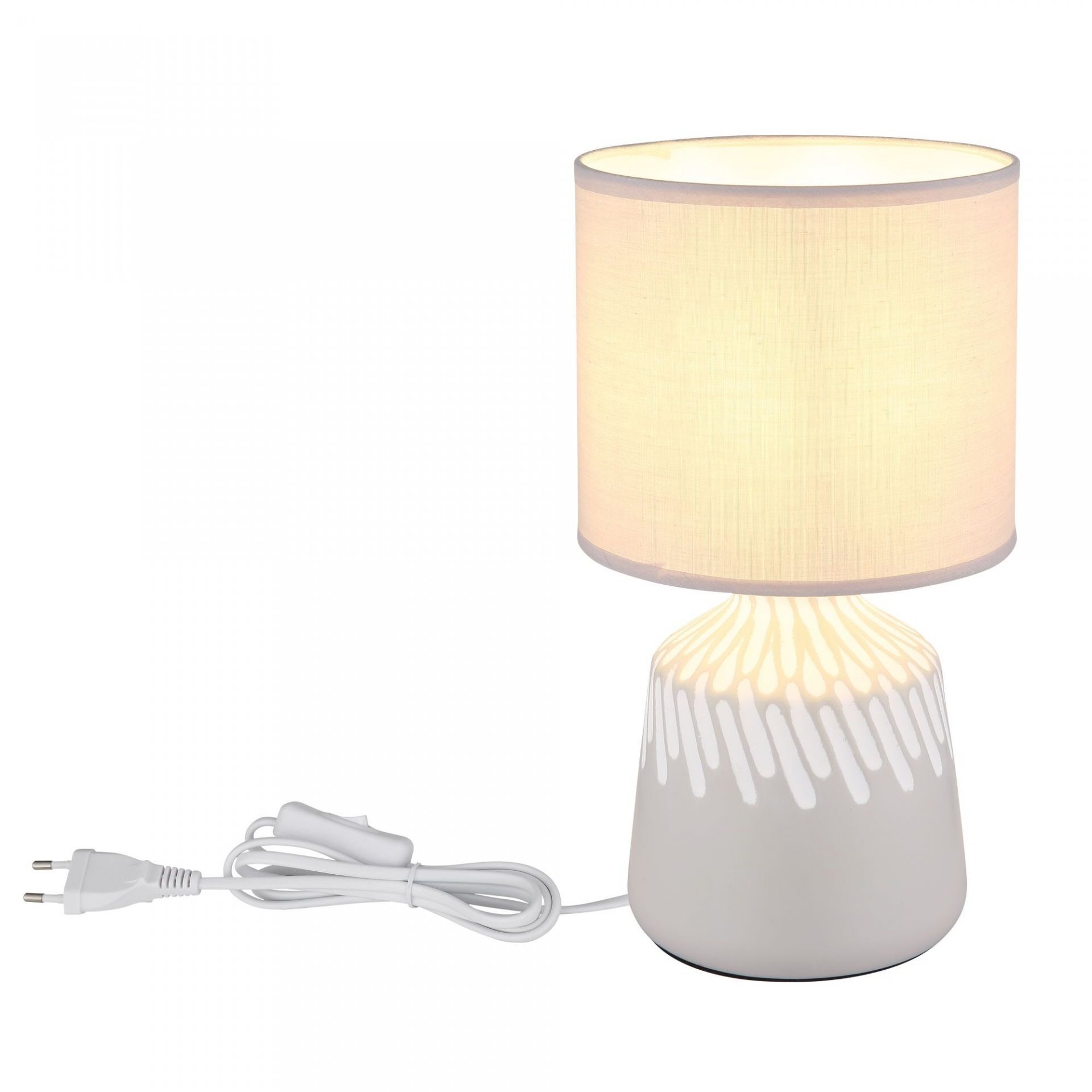 Na obrazie widoczna jest lampa stołowa z białym abażurem i ceramiczną podstawą w białym kolorze z dekoracyjnym wzorem. Lampa posiada biały przewód z wtyczką i przełącznikiem.