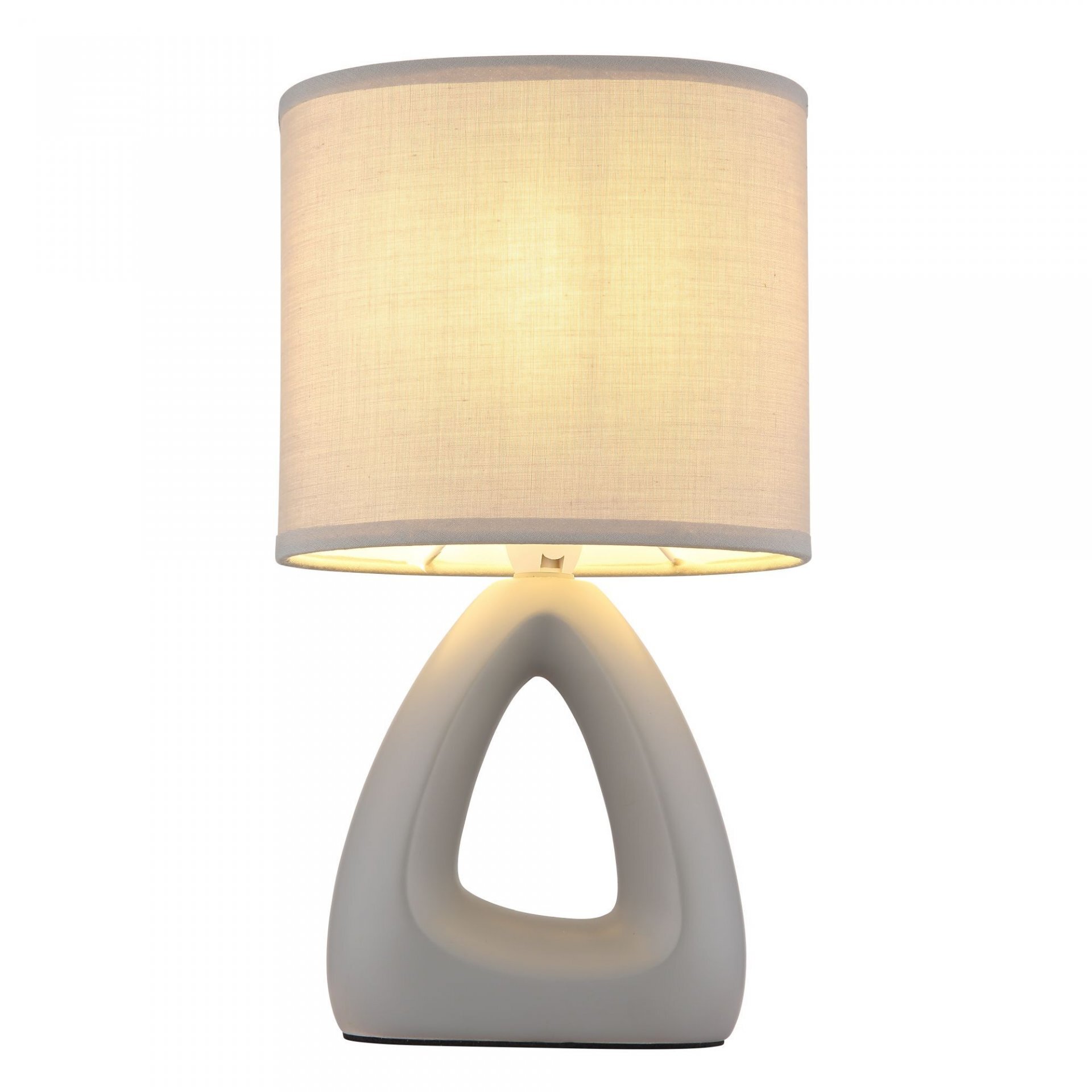Na obrazie widoczna jest nowoczesna lampa stołowa z trójkątną podstawą i cylindrycznym abażurem w jasnym kolorze. Lampa emituje ciepłe, rozproszone światło.
