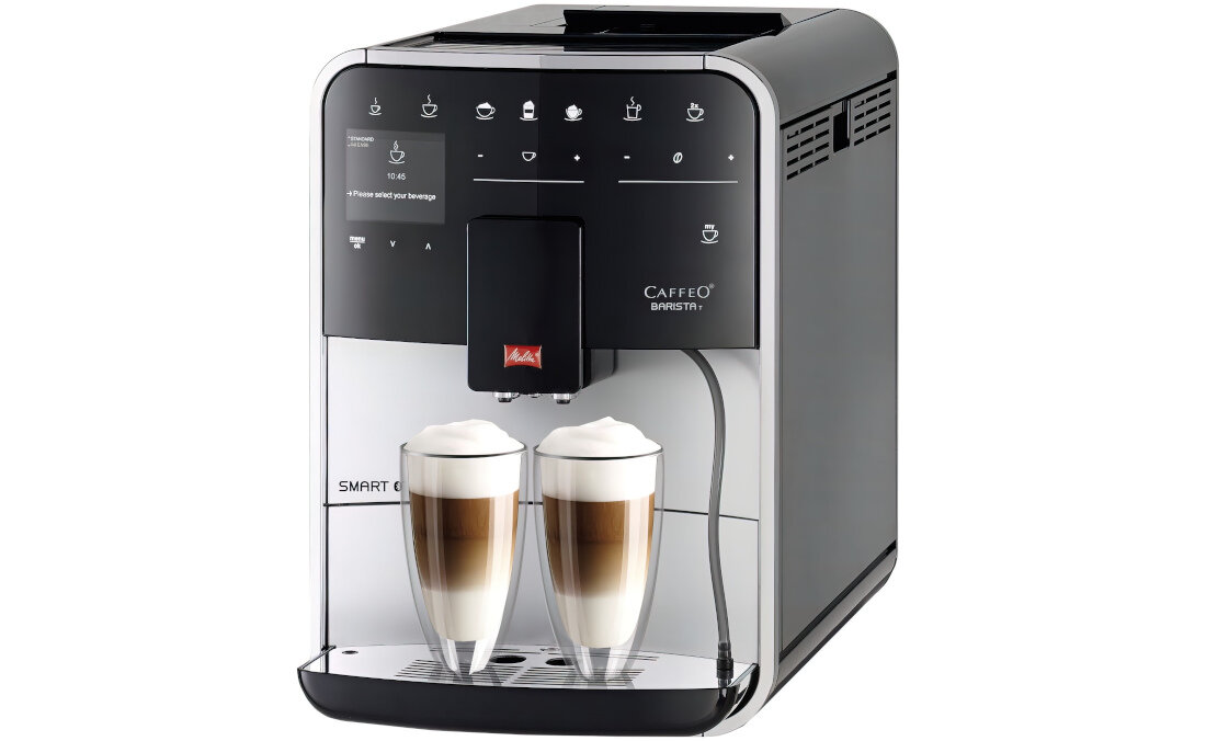 Ekspres do kawy z wyświetlaczem i przyciskami dotykowymi, na którym widoczne są dwa szklane kubki z kawą. Na urządzeniu znajduje się logo MELITTA oraz napisy \'CAFFEO BARISTA T\' i \'SMART ONE TOUCH\'.