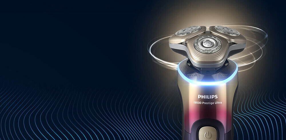 Golarka z trzema okrągłymi głowicami, na których widoczne są detale mechanizmu. Na obudowie znajduje się napis \'PHILIPS 9000 Prestige Ultra\'.
