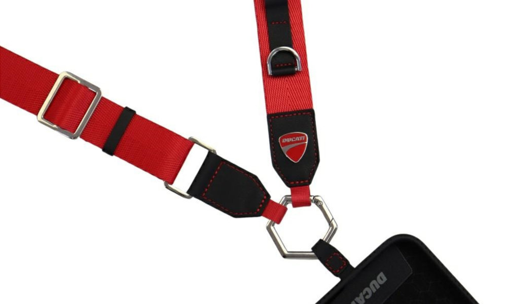Czerwona smycz do telefonu z metalowymi zapięciami i logo Ducati na czarnym tle. Smycz jest przymocowana do etui na telefon z napisem \'DUCATI\'.