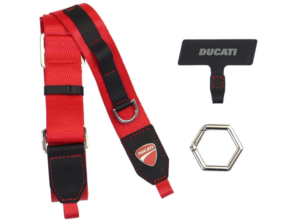Czerwona smycz do telefonu z czarnymi akcentami i logo \'DUCATI\'. Obok smyczy znajduje się czarny uchwyt z napisem \'DUCATI\' oraz metalowy sześciokątny pierścień.