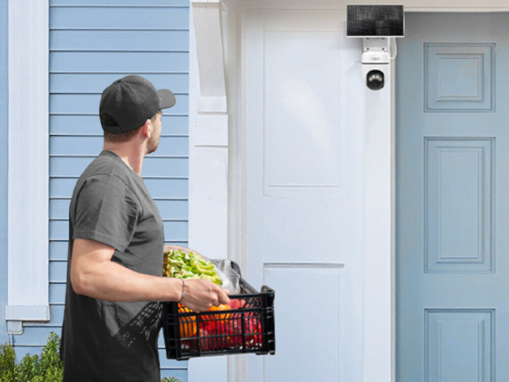 Kamera TP-LINK Tapo C610 Zewnętrzna, Wi-Fi, Kamera obrotowa, mikrofon, głośnik, rozmowa, kontakt, mężczyzna idzie przed kamerą z koszem warzyw i obserwuje kamerę