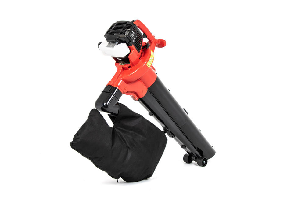 Na obrazie widoczny jest czerwono-czarny odkurzacz do liści z dużym workiem na odpady. Urządzenie posiada dwa kółka ułatwiające przemieszczanie.