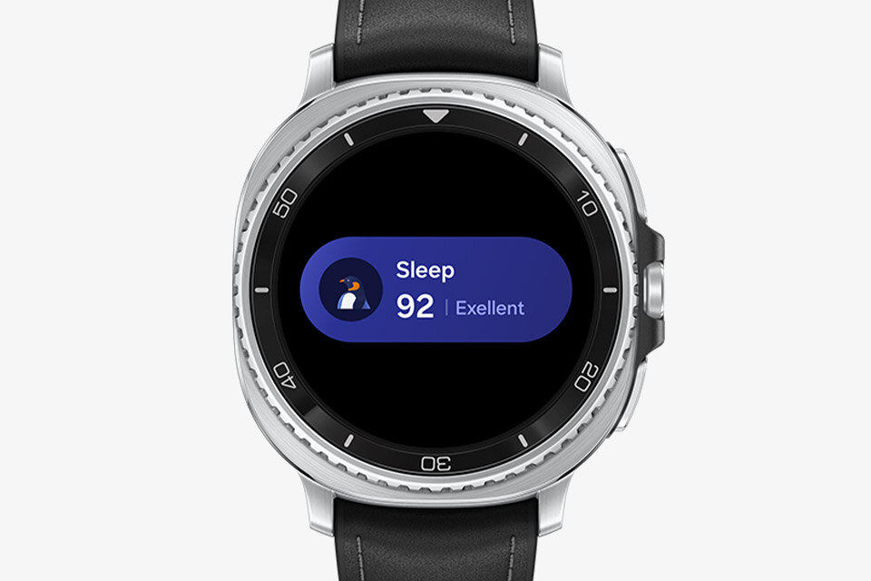 Smartwatch z okrągłym wyświetlaczem pokazuje ekran z informacją \'Sleep 92 | Exellent\'. Urządzenie ma srebrną ramkę i czarny pasek.
