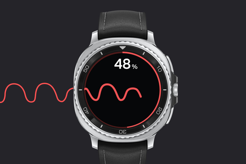 Smartwatch z okrągłym wyświetlaczem pokazuje wartość 48% oraz czerwoną falującą linię na czarnym tle. Pasek zegarka jest czarny, a koperta srebrna.