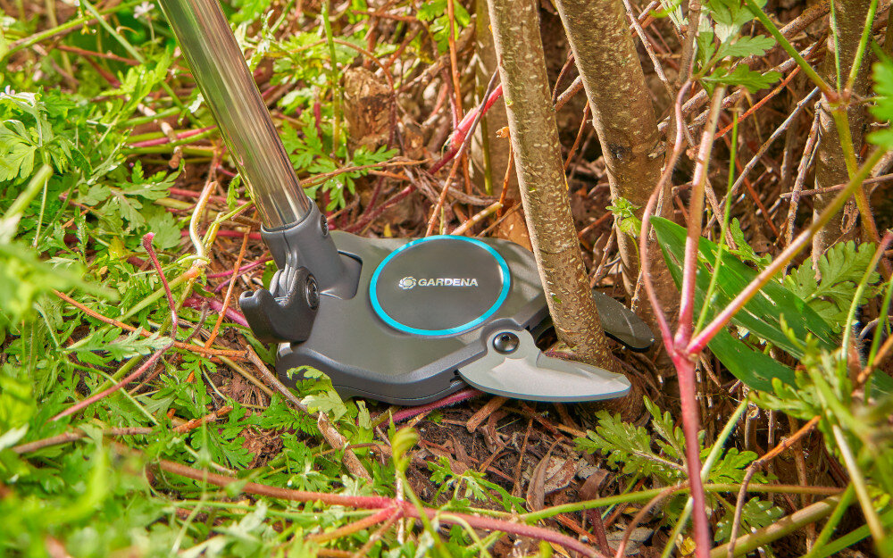 Sekator teleskopowy GARDENA StarCut Pro S 12080-20 ogród zbliżenie na głowicę sekatora sekator podcina gałęzie głowica tnąca jest niewielka i obudowana zapobiega zaczepianiu się o gałęzie  możliwość regulacji kąta cięcia z poziomu podłoża