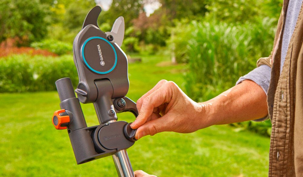 Sekator teleskopowy GARDENA StarCut Pro S 12080-20 ogród trawnik w tle drzewa krzewy kwiaty osoba trzyma sekator w dłoniach precyzyjnie szlifowane ostrza z wysokiej jakości stali pokryto powłoką PowerCoating płynne cięcie i wydłuża trwałość narzędzia