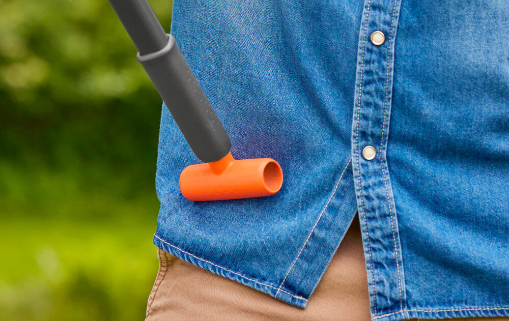 Sekator teleskopowy GARDENA StarCut Pro S 12080-20 zbliżenie na uchwyt osoba opiera sekator o biodro rozmazane tło dolna rękojeść oferuje pewny uchwyt dodatkowy uchwyt w kształcie litery T prosty mechanizm zacisku łatwe w użytkowaniu