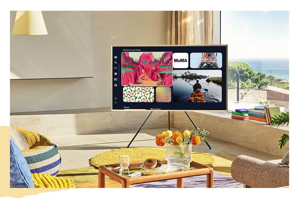 Telewizor Frame ustawiony na stojaku Studio Stand w salonie wyświetla ekran Art Home z niektórymi dostępnymi pracami