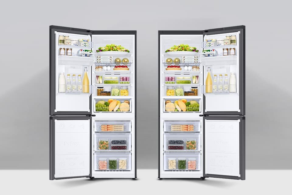 Dwie otwarte lodówki z widocznymi półkami wypełnionymi różnorodnymi produktami spożywczymi, takimi jak butelki, owoce, warzywa i pojemniki z jedzeniem. W dolnej części znajdują się zamrażarki z przezroczystymi szufladami.