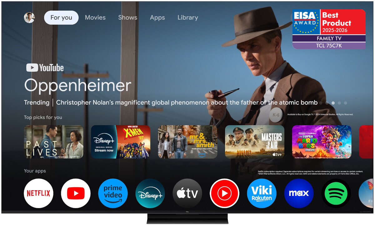 Ekran telewizora wyświetla interfejs Google TV z aplikacjami takimi jak Netflix, YouTube, Prime Video, Disney+, Apple TV, oraz inne. W prawym górnym rogu widoczne jest logo EISA Award z napisem \'Best Product 2025-2026 FAMILY TV TCL 75C7K\'.