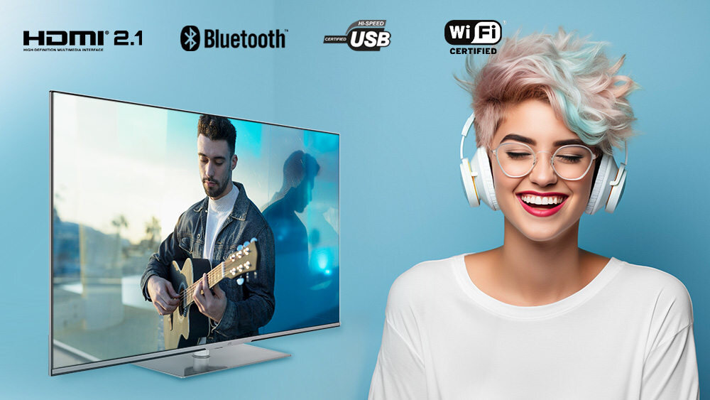 Obraz przedstawia telewizor z wyświetlanym na ekranie mężczyzną grającym na gitarze oraz osobę z kolorowymi włosami i słuchawkami na uszach. Na górze widoczne są logotypy: HDMI 2.1, Bluetooth, Hi-Speed USB, WiFi Certified.