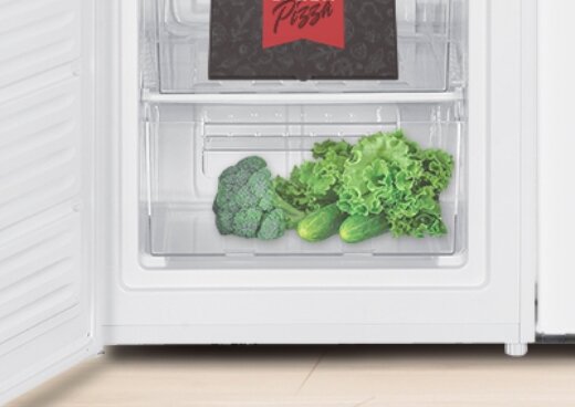 Wnętrze zamrażarki, zbliżenie na szufladę z warzywami.