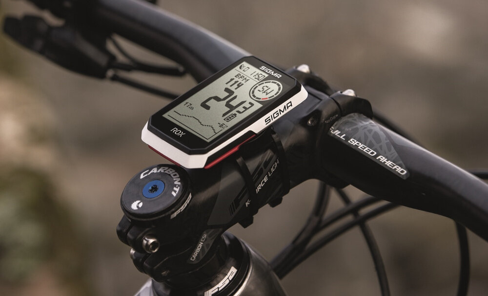 Licznik rowerowy z wyświetlaczem pokazującym prędkość 24,3 km/h, czas 11:11 i inne dane. Na urządzeniu widoczne jest logo SIGMA.