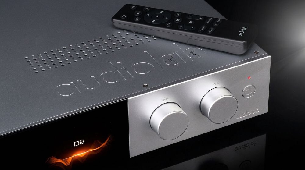 Na obrazie widoczny jest przetwornik C/A z napisem \'audiolab\' oraz pilot zdalnego sterowania. Na wyświetlaczu urządzenia widnieje napis \'D9\'.