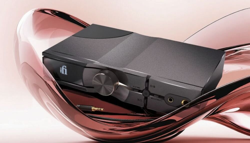Przetwornik C/A IFI AUDIO Neo iDSD 3 Burr-Brown DAC PCM DSD oddzielne ścieżki naturalna dynamika, wzmacniacz audio marki iFi wyeksponowany na płynnej, błyszczącej powierzchni w odcieniu różowego złota