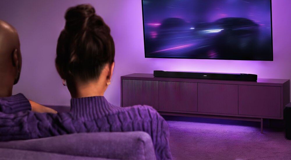 BOSE LIFESTYLE ULTRA Bass Module kalibracja dźwięku dopasowanie do pomieszczenia optymalna akustyka, osoby siedzące na kanapie oglądające telewizje