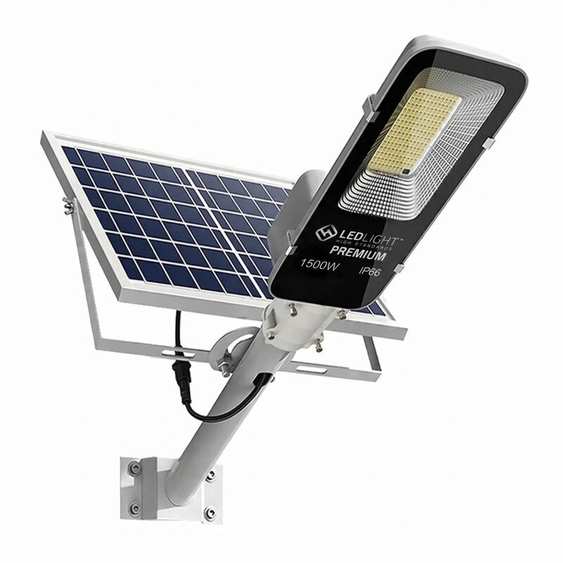 Obraz przedstawia lampę solarną LED z panelem słonecznym i napisem \'LEDLIGHT PREMIUM 1500W IP66\' na obudowie. Lampa jest zamontowana na metalowym uchwycie.