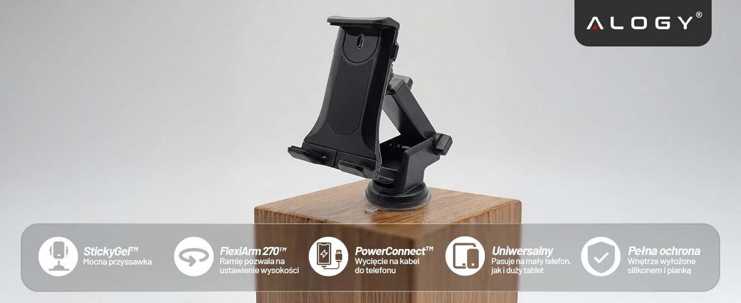 Na drewnianym bloku znajduje się czarny uchwyt samochodowy na telefon z przyssawką. Na dole obrazu widoczne są ikony z tekstem: \'StickyGel™ Mocna przyssawka\', \'FlexiArm 270™ Ramię pozwala na ustawienie wysokości\', \'PowerConnect™ Wycięcie na kabel do telefonu\', \'Uniwersalny Pasuje na mały telefon, jak i duży tablet\', \'Pełna ochrona Wnętrze wyłożone silikonem i pianką\'.
