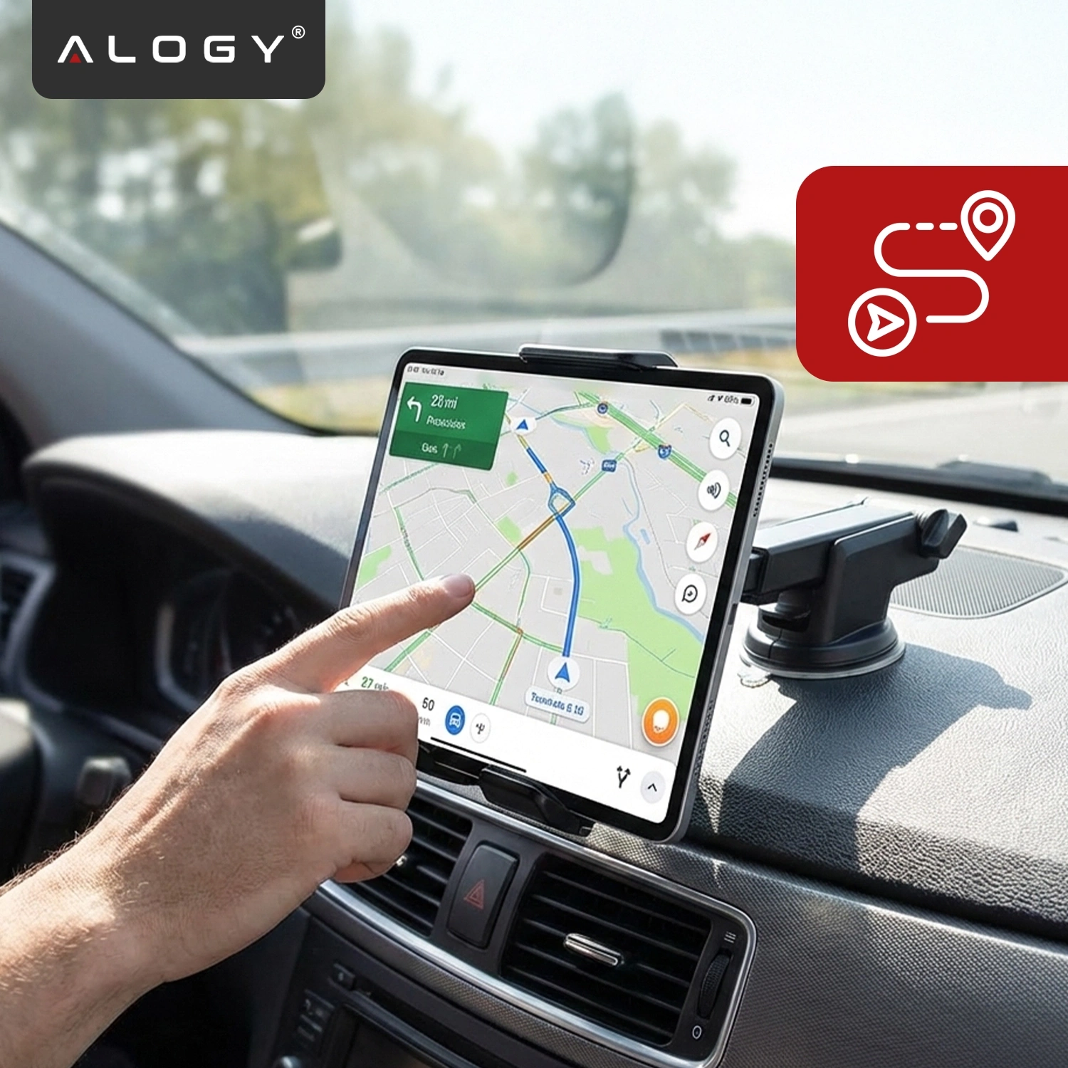 Na zdjęciu widać tablet zamocowany w uchwycie samochodowym na desce rozdzielczej, z wyświetloną mapą na ekranie. W lewym górnym rogu znajduje się logo \'ALOGY\'.