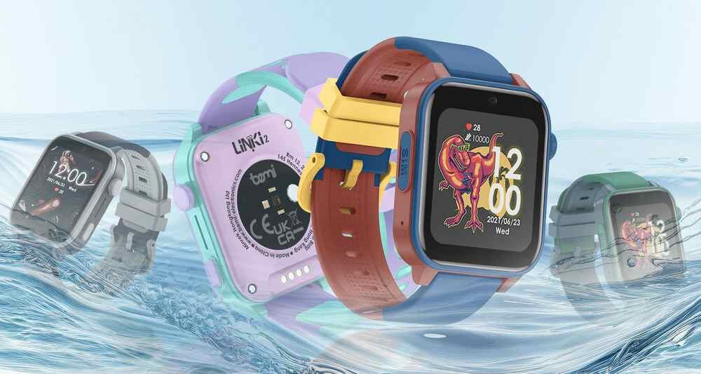 Na obrazie widoczne są cztery smartwatche w różnych kolorach, zanurzone częściowo w wodzie. Na jednym z wyświetlaczy widoczna jest godzina 12:00 oraz data 2023/06/28 z kolorową grafiką dinozaura.