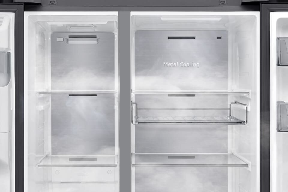 Wnętrze lodówki z widocznymi półkami i napisem \'Metal Cooling\' na tylnej ściance. Wnętrze jest oświetlone, a powierzchnie są wykonane z metalu i szkła.
