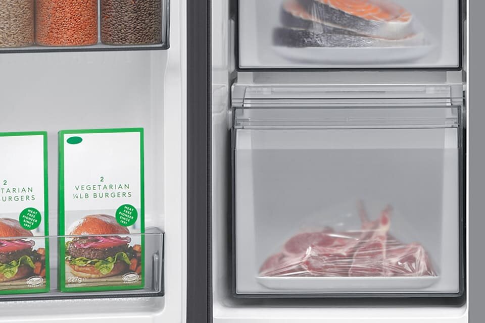 Wnętrze lodówki z widocznymi produktami spożywczymi: opakowania z napisem \'2 VEGETARIAN 1/4LB BURGERS\', kawałki ryby oraz mięso w przezroczystych pojemnikach.