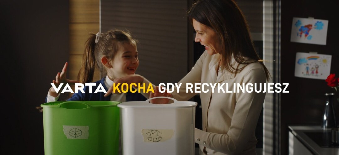 Uśmiechnięta kobieta i dziewczynka wrzucają odpady do pojemników do recyklingu.
